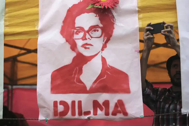 Apoiador de Dilma Rousseff (PT) tira foto de banners com a imagem da presidente durante uma marcha em São Paulo (Nacho Doce/Reuters)