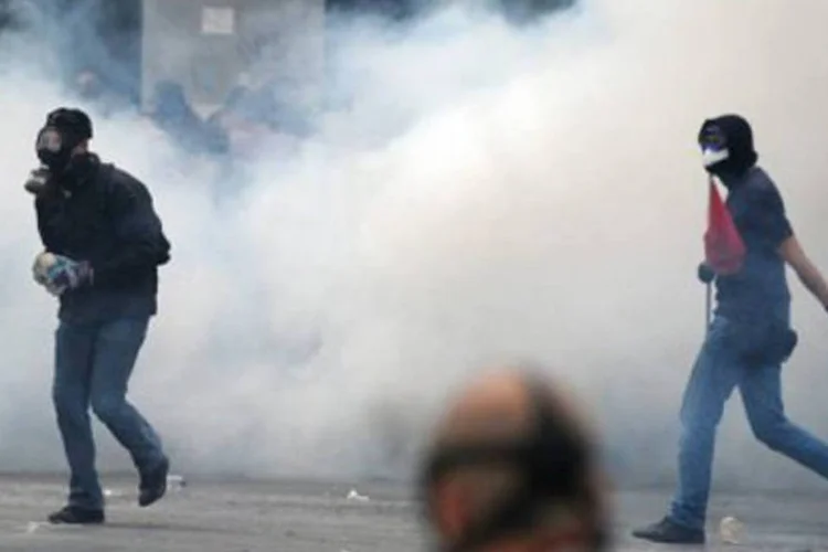 Participantes de protesto contra plano de austeridade caminham em meio a uma nuvem de fumaça (.)