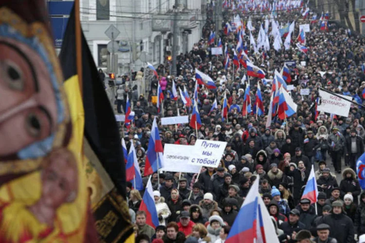
	Manifestantes durante uma marcha no centro de Moscou:&nbsp;manifestantes portam bandeiras russas e cartazes com frases como:&nbsp;&quot;Acreditamos em Putin&quot;
 (Sergei Karpukhin/Reuters)