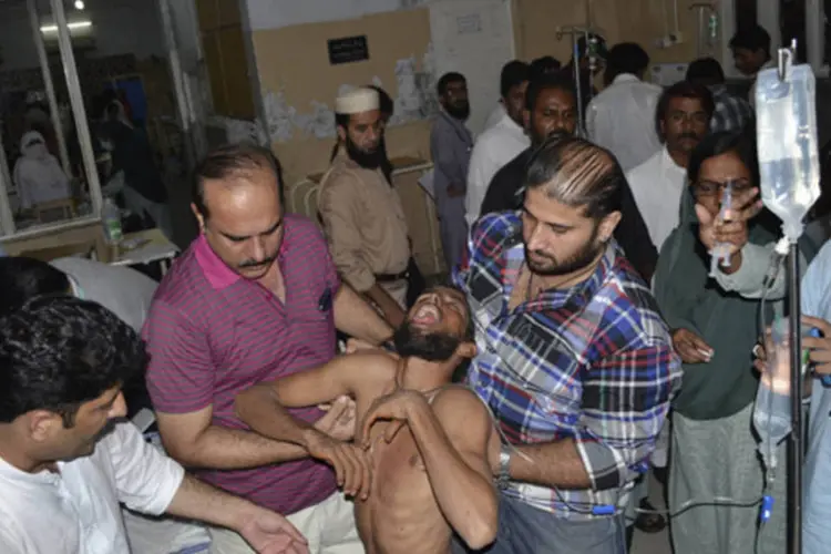 Apoiador de Imran Khan é ajudado por homens em hospital após se ferir em confusão durante protesto em Multan (K. Chaudhry/Reuters)