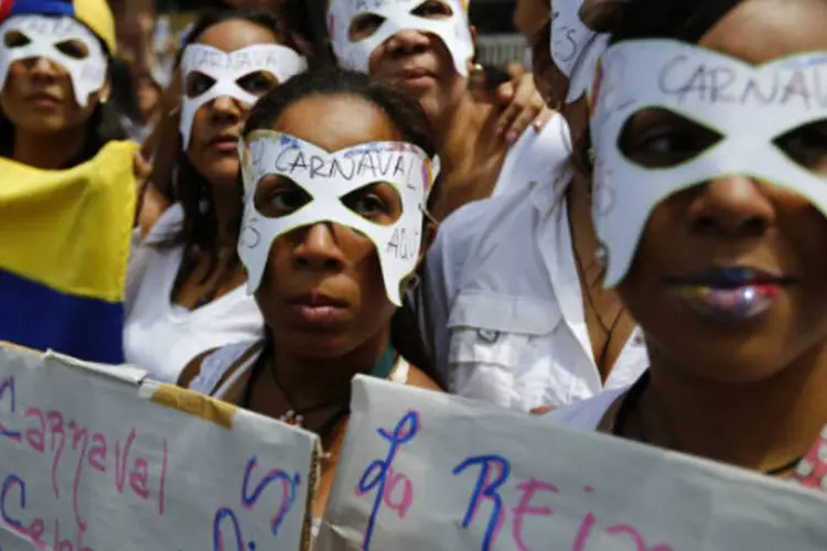 Manifestantes com máscaras de carnaval protestam contra o governo da Venezuela: o presidente Nicolás Maduro, no entanto, manteve a programação de carnaval  (Jorge Silva/Reuters)