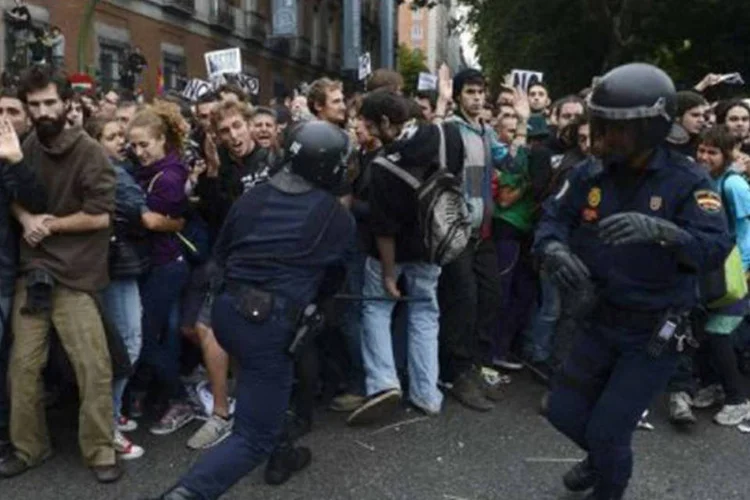 
	Pol&iacute;cia enfrenta manifestantes durante protesto em Madri: a AI criticou tamb&eacute;m as pris&otilde;es arbitr&aacute;rias e a dificuldade de acesso ao atendimento m&eacute;dico
 (Pierre-Philippe Marcou/AFP)