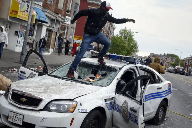 Manifestante pula em carro de polícia durante protesto em Baltimore, Maryland, EUA (Shannon Stapleton/Reuters)