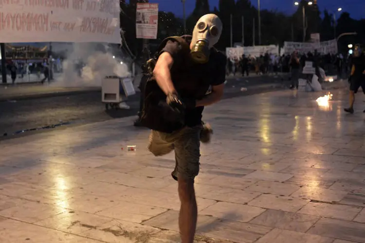 Manifestante em confronto com polícia em Atenas, na Grécia, na última quarta-feira (15/07) (Milos Bicanski/Getty Images)