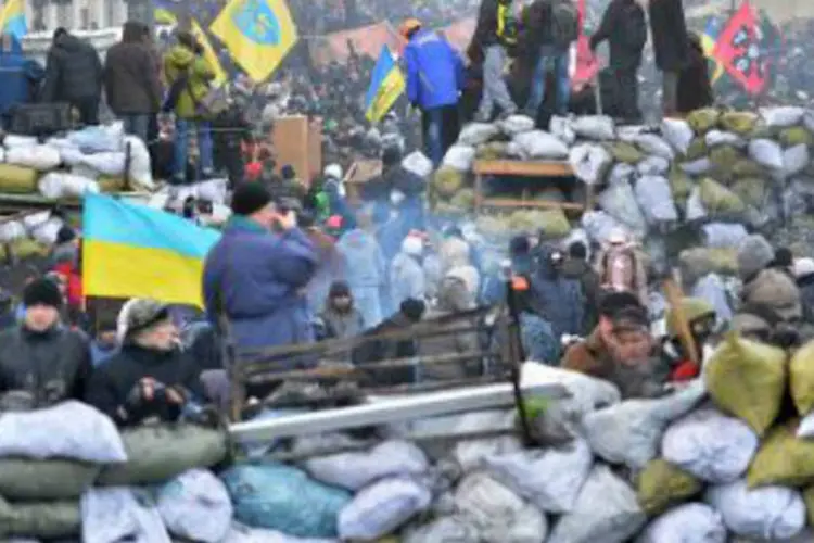 
	Manifestantes ucranianos atr&aacute;s de barricadas, no centro de Kiev: Continua pouco claro se um consenso pode ser alcan&ccedil;ado para se mudar a Constitui&ccedil;&atilde;o
 (Sergei Supinsky/AFP)