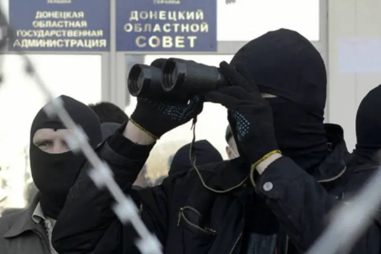 Um manifestante pró-russo olha por seus binóculos perto da entrada de prédio da administração de Donetsk (Maks Levin/Reuters)