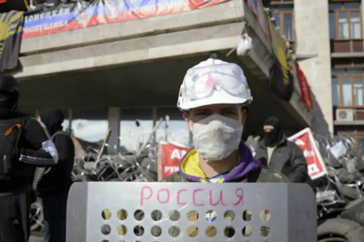 
	Manifestante pr&oacute;-R&uacute;ssia em frente a uma barrica fora do pr&eacute;dio de administra&ccedil;&atilde;o regional de Donetsk, Ucr&acirc;nia
 (Maks Levin/Reuters)