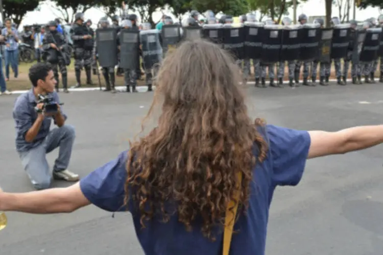 Manifestante com garrafa de vinagre na mão em frente a cordão de isolamento da Polícia Militar durante protesto no Estádio Nacional Mané Garrincha, em Brasília (Valter Campanato/ABr)