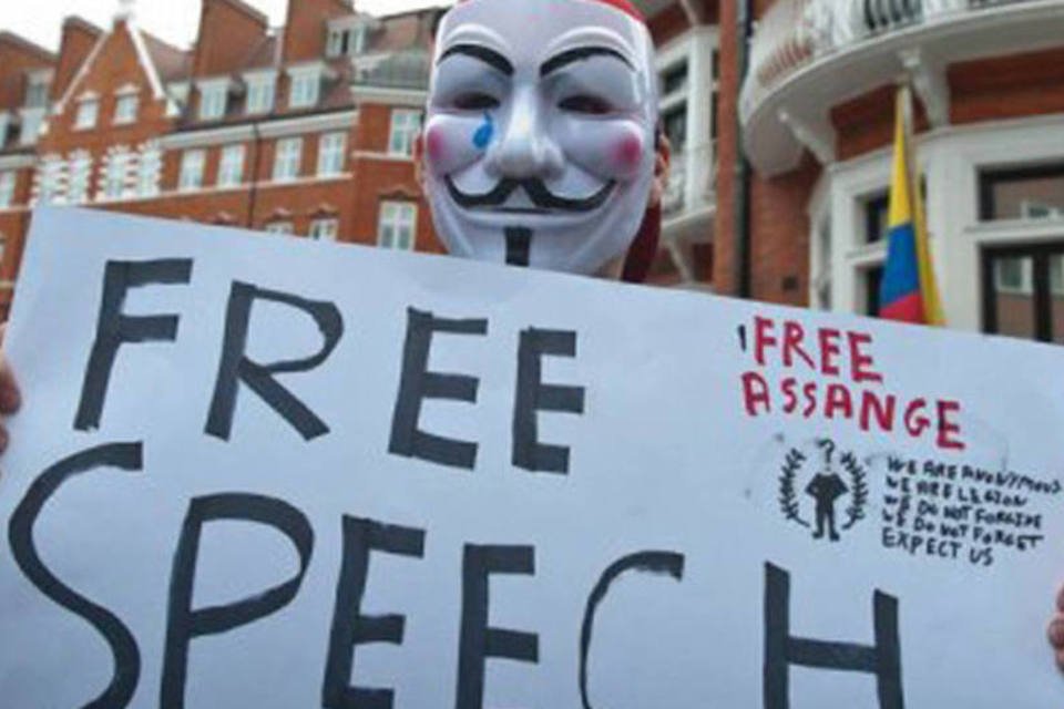 Um mascarado exibe um cartaz pedindo liberdade de expressão diante da embaixada do Equador em Londres nesta quinta