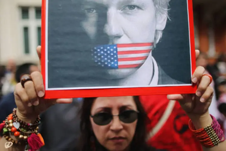
	Mulher segura cartaz com os dizeres &quot;eu sou Assange&quot; em frente &agrave; embaixada do Equador em Londres: O documento foi aprovado sem que houvesse uma vota&ccedil;&atilde;o
 (Dan Kitwood/ Getty Images)