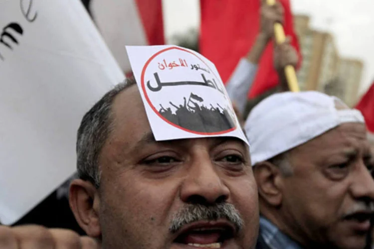Manifestante protesta contra nova constituição do Egito: alguns carregam cartazes em favor da polêmica declaração constitucional promulgada por Mursi (REUTERS)