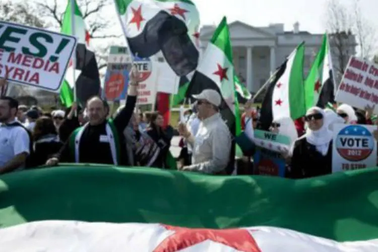 Manifestantes simpáticos à oposição síria participam de marcha de protesto contra o regime em frente à Casa Branca, em Washington (AFP)