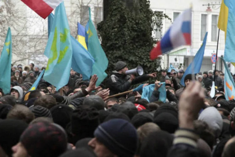 
	Manifestantes a favor da R&uacute;ssia e da Ucr&acirc;nia em frente ao Parlamento da rep&uacute;blica aut&ocirc;noma da Crim&eacute;ia:&nbsp;um grupo tomou as sedes do Parlamento e do governo
 (Stringer/Reuters)
