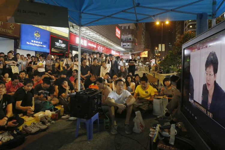 Prinunciamento de Carrie Lam: “para aqueles que, contra a lei, ocupam as vias, solicitamos que vocês deixem as áreas rápida e pacificamente” (Bobby Yip/Reuters)