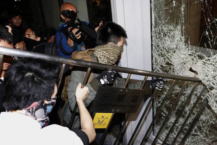 Manifestantes quebram vidro: quatro pessoas, de idades entre 18 e 24 anos, foram presas, e três policiais foram levados ao hospital com ferimentos (Tyrone Siu/ Reuters)