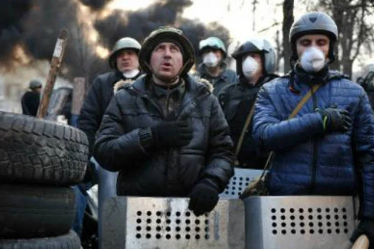 Manifestantes em uma barricada na Praça da Independência, em Kiev: acordo prevê concessões à oposição (Louisa Gouliamaki/AFP)