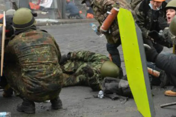 Manifestantes na praça Maidan, em Kiev, depois de serem baleados: justiça anunciou detenção de 11 policiais e seus comandantes por envolvimento nos distúrbios (Sergei Supinsky/AFP)