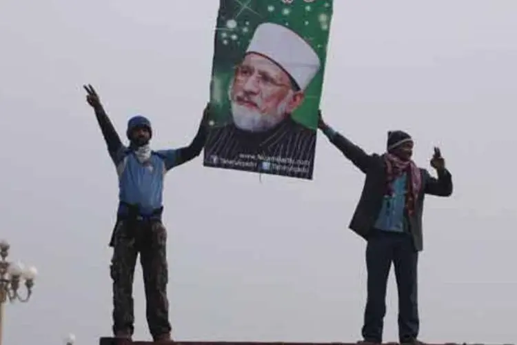 
	Manifestantes exibem faixa com figura do l&iacute;der religioso Muhammad Tahirul Qadri durante protestos no Paquist&atilde;o
 (Akhtar Soomro / Reuters)