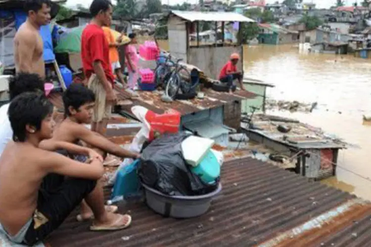 Subúrbio de Manila: moradores da capital das Filipinas se refugiam nos telhados (Jay Directo/AFP)