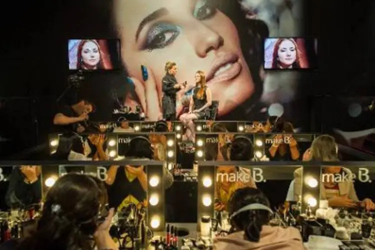 Mulheres aprendem a se maquiar na São Paulo Fashion Week (Yasuyoshi Chiba/AFP)