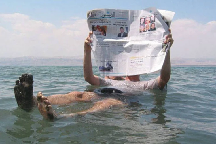 É possível boiar nas águas densas do Mar Morto, aproveitando a alta salinidade que facilita a flutuação (Wikimedia Commons)