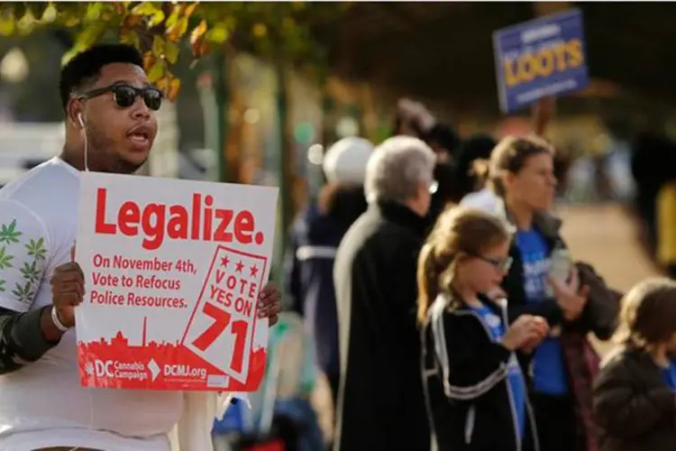 Homem faz campanha a favor da legalização da maconha perto de uma seção eleitoral de Washington (REUTERS/Gary Cameron)