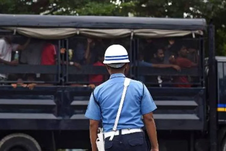 Oficial da Marinha da Malásia observa veículo com imigrantes bengaleses em centro de detenção temporário (Manan Vatsyayana/AFP)