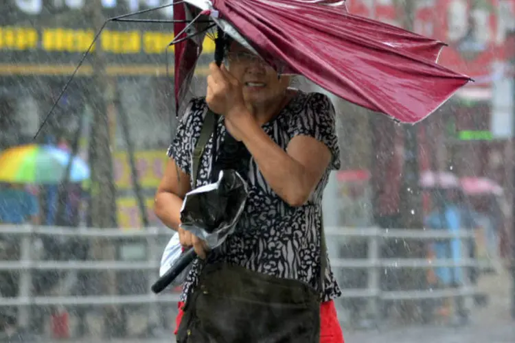 Mulher caminha durante tempestade causada pelo tufão Matmo, na China (Stringer/Reuters)