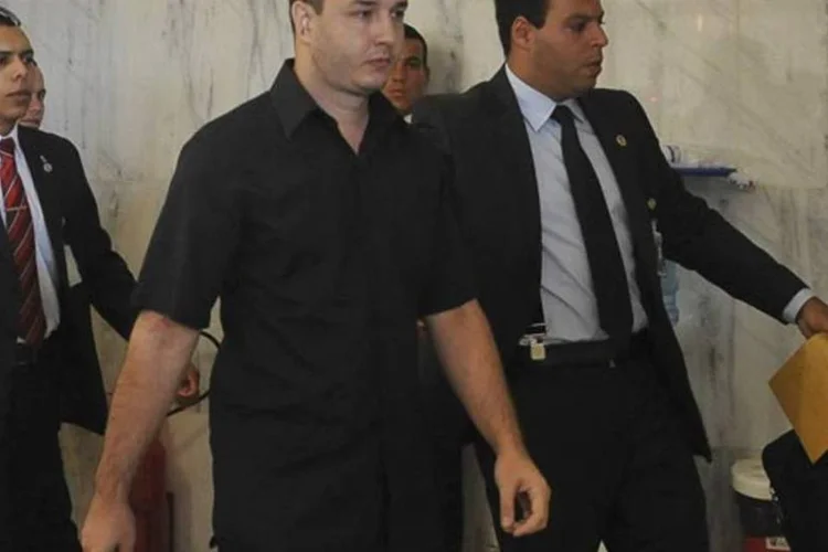 Maycon Kuster Pinheiro é levado por seguranças: ele foi encaminhado para a Polícia Federal (Antonio Cruz/ABr)