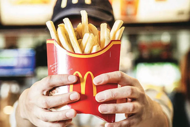 
	Funcion&aacute;rio do McDonald&#39;s oferece batatas fritas: diante de um cen&aacute;rio econ&ocirc;mico mais fraco para o consumo na Am&eacute;rica Latina e Caribe, a Arcos Dorados colocar&aacute; o p&eacute; no freio
 (Paulo Pampolin / Hype)
