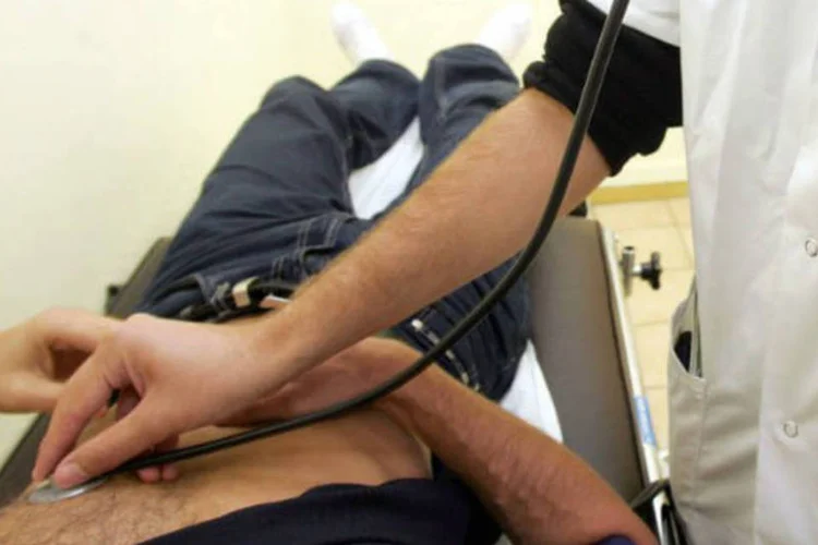 
	M&eacute;dico examina paciente: na semana passada, a dire&ccedil;&atilde;o do hospital j&aacute; havia informado que est&aacute; se adaptando &agrave;s novas regras para a compra de material b&aacute;sico.
 (AFP / Gerard Julien)