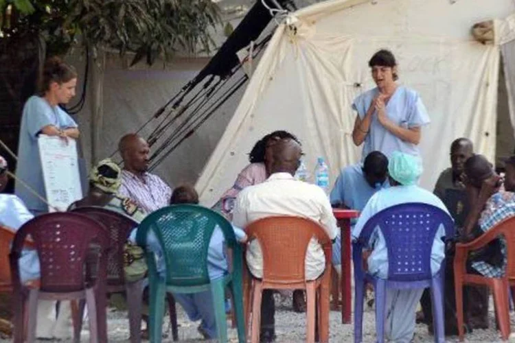 Médicos conversam com parentes de pessoas infectadas pelo vírus Ebola, na Guiné: pesquisas devem prosseguir para identificar a fonte animal do vírus (Cellou Binani/AFP)