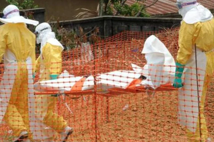 
	M&eacute;dicos removem o corpo de uma v&iacute;tima do Ebola: epidemia j&aacute; deixou cerca de 900 v&iacute;timas
 (AFP)