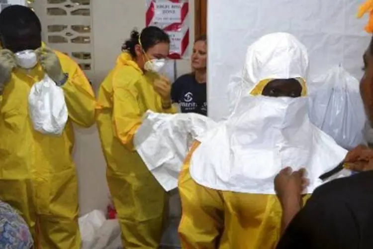 Médicos vestem roupas de proteção ao Ebola na Libéria (Zoom Dosso/AFP)
