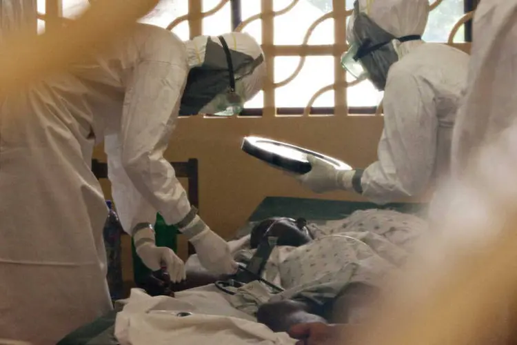 
	M&eacute;dicos da Samaritan&#39;s Purse tratando paciente contaminado com ebola, na Lib&eacute;ria
 (Samaritans Purse/Divulgação via Reuters)