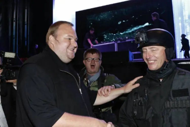 O fundador do Megaupload Kim Dotcom cumprimenta um ator vestido de policial durante o lançamento de seu novo site de compartilhamento de arquivos, o Mega (REUTERS / Nigel Marple)