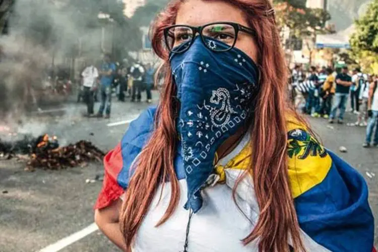 
	Manifestante na Venezuela: manifesta&ccedil;&otilde;es opositoras se sucedem diariamente desde 12 de fevereiro
 (Cristian Hernandez/ AFP Photo)
