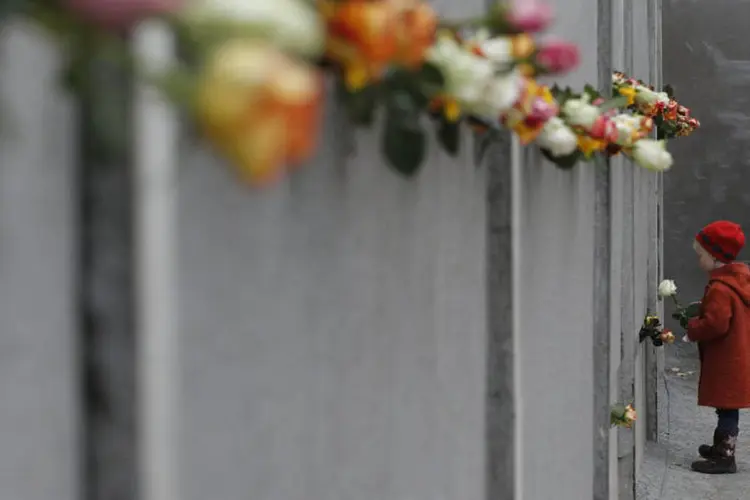 
	Menina coloca flores no memorial do Muro de Berlim
 (REUTERS/Fabrizio Bensch)
