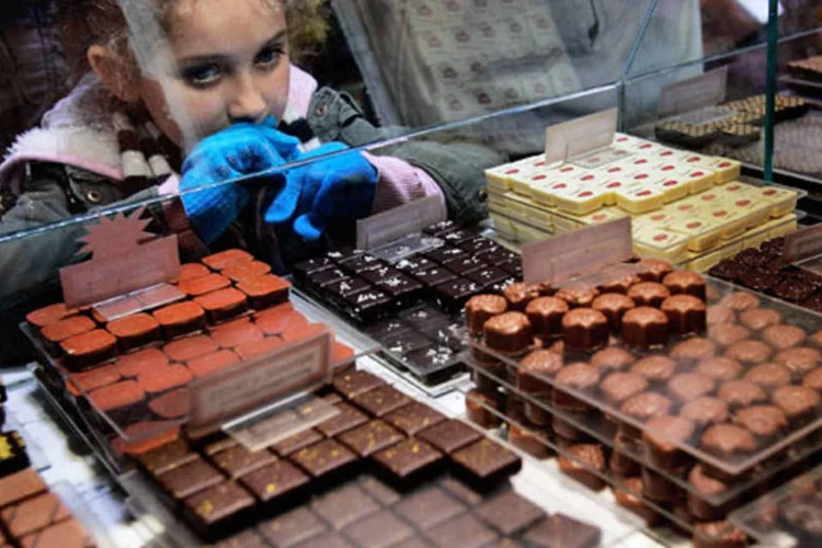 Criança olha vitrine de bombons de chocolate (Getty Images)