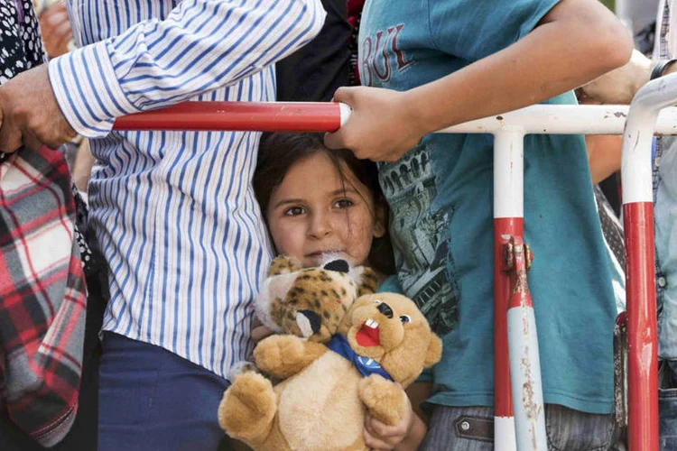 
	Menina entre refugiados que chegaram a Munique, na Alemanha
 (Reuters / Lukas Barth)
