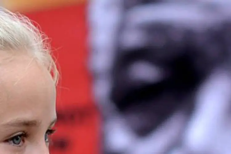 menina chora em frente a foto de Mandela (AFP)