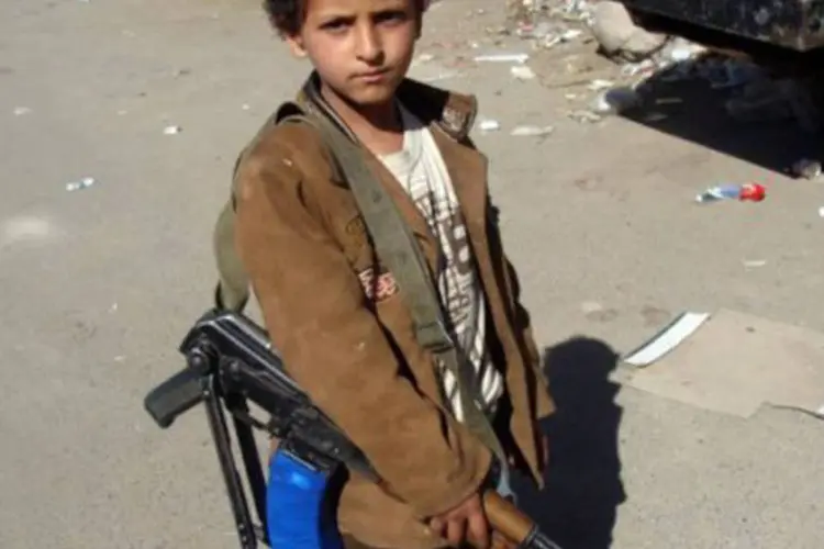 Menino armado acompanha membros da Al Qaeda no Iêmen, em janeiro de 2012
 (AFP)