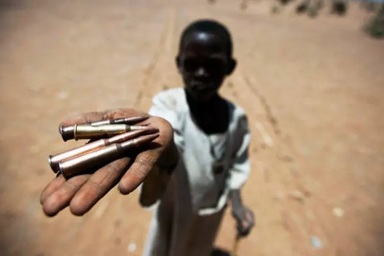Tensão latente: criança segura balas recolhidas do chão no norte de Darfur, no Sudão, em foto de março de 2011. (UN / Albert González Farran)
