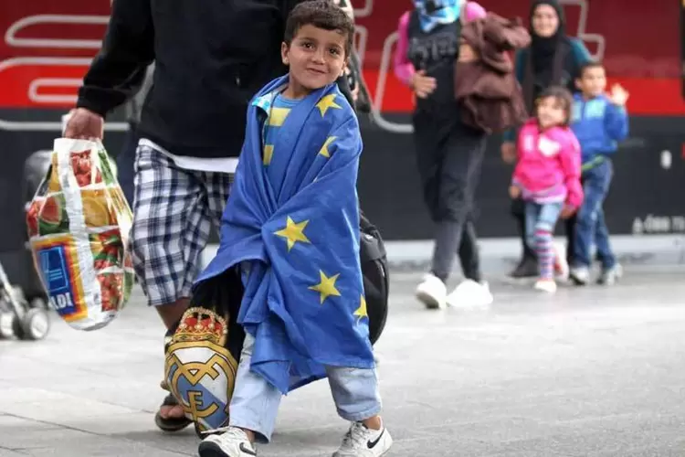 
	Menino refugiado envolto em uma bandeira da UE: Alemanha, Fran&ccedil;a e Espanha ser&atilde;o os tr&ecirc;s pa&iacute;ses mais solicitados para asilo, recebendo 31.443, 24.031 e 14.931 refugiados, respectivamente
 (Gettyimages)