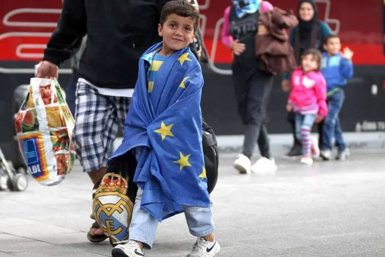 
	Menino refugiado envolto em uma bandeira da Uni&atilde;o Europeia: 20 refugiados eritreus partir&atilde;o do aeroporto romano de Ciampino rumo &agrave; Su&eacute;cia
 (Gettyimages)