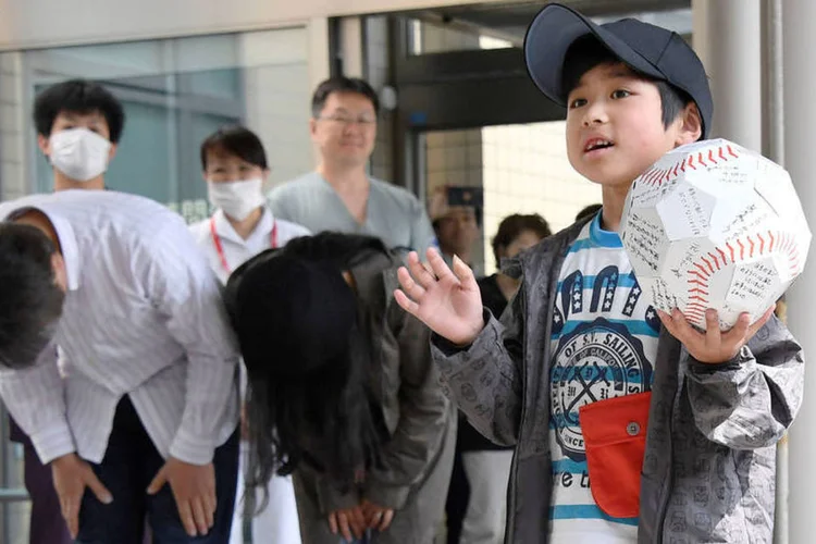 
	Yamato Tanooka: sorridente, ele exibia uma grande bola de beisebol de papel repleta de assinaturas, um prov&aacute;vel presente da equipe m&eacute;dica
 (Kyodo / Reuters)
