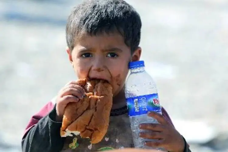 Menino da comunidade yazidi come um pedaço de pão no norte do Iraque, na fronteira com a Síria (Ahmad al-Rubaye/AFP)