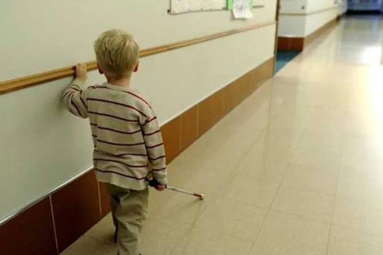
	Menino cego caminha no corredor da escola para deficientes visuais St. Josephs em Nova Jersey
 (AFP/ Timothy A. Clary)