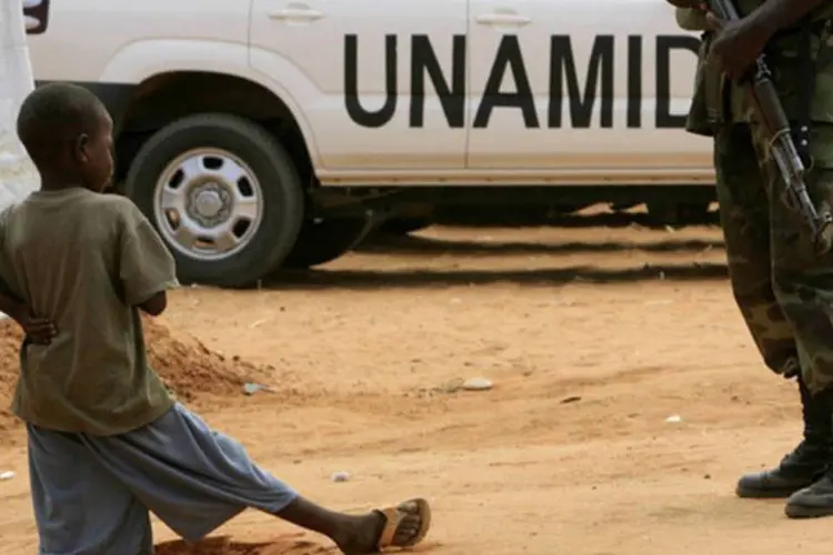 Menino observa um soldado UNAMID em El-Fasher, Darfur: os dois soldados desapareceram no dia 20 de agosto na cidade de Kebkabiya, 140 km a oeste de El Fasher (©afp.com / Ashraf Shazly)