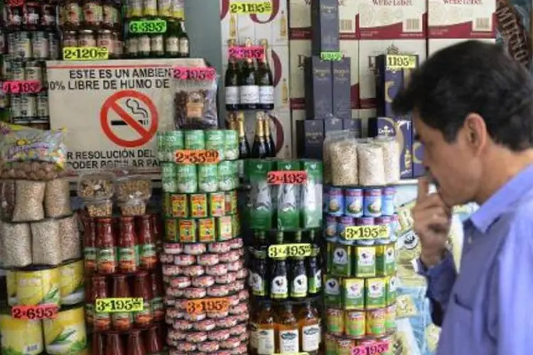 
	Um homem observa os pre&ccedil;os de um mercado de Caracas: 35 unidades da rede Dia a Dia passar&atilde;o a ser assimiladas pela ag&ecirc;ncia estatal neste fim de semana
 (Leo Ramirez/AFP)